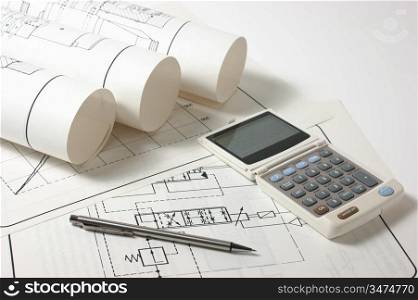 rolled technical drawings and a calculator