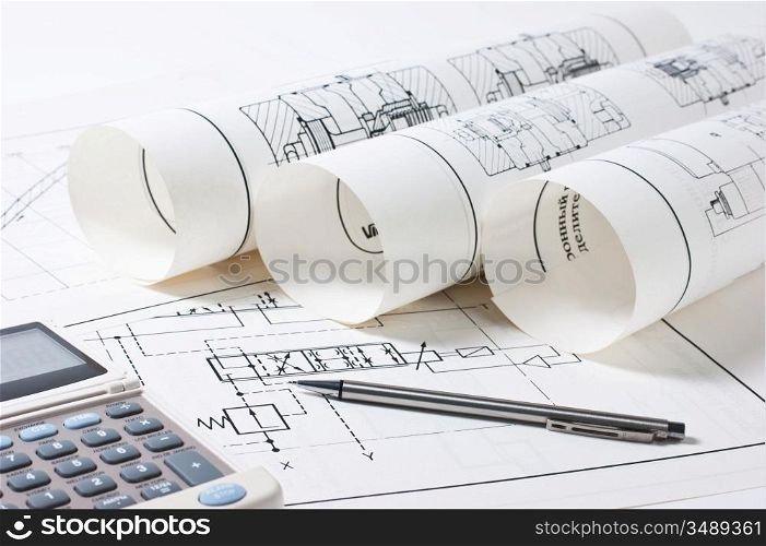 rolled technical drawings and a calculator