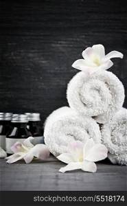 Rolled up towels and products at spa. White rolled up towels with body care products at spa