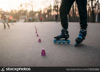 Roller skater legs in skates on asphalt walkway in city park. Male rollerskater leisure