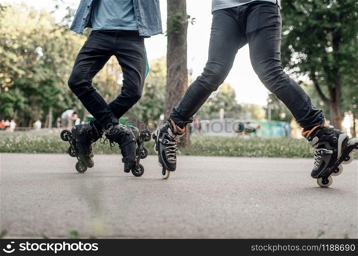 Roller skating, two male teenagers rolling in park. Urban roller-skating, active extreme sport outdoors