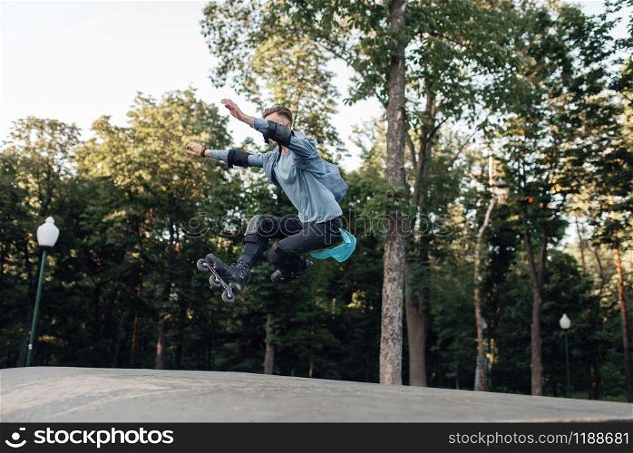 Roller skating, young male skater jumping on ramp. Urban roller-skating, active extreme sport outdoors