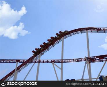 rollercoaster in an amusement park against blue sky. rollercoaster in an amusement park