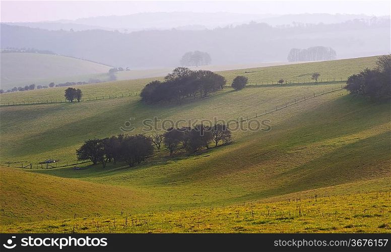 Rolling landscape over hills and valleys on haxzy sunny evening