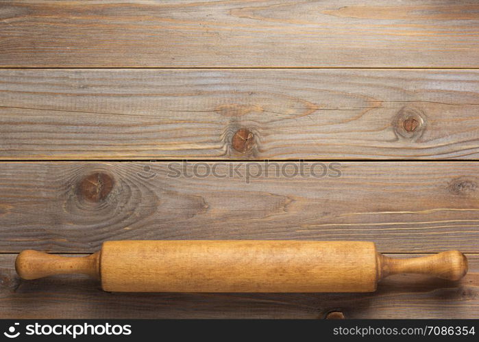 rolling pin at wooden board rustic plank table background, top view