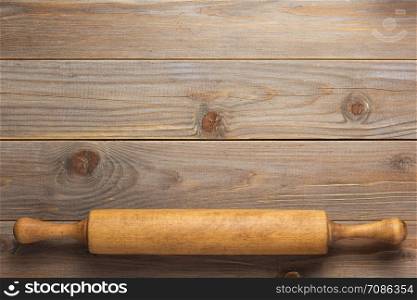 rolling pin at wooden board rustic plank table background, top view