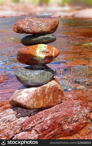 Rolling stones stacked red rodeno limestone in river Pyrenees