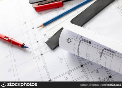 Rolls of architecture blueprints and house plans on the table and architect drawing tools. 