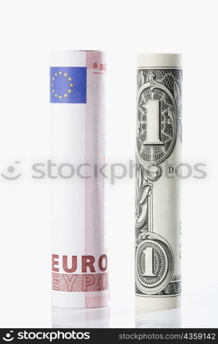 Rolls of European union euro note with US paper currency