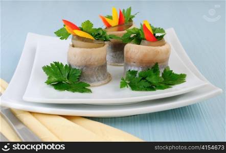 Rolls of herring fillets with pickled cucumber and pepper and parsley