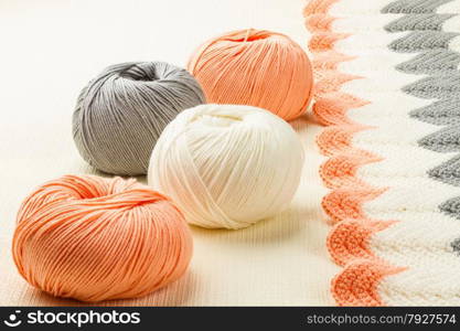 rolls of soft knitting yarn and knitting on white background