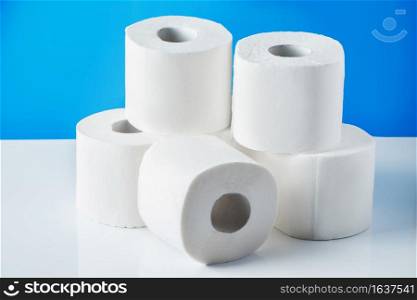 Rolls of toilet paper on a blue background. Panic purchase of essential goods. The coronavirus pandemic in the world.. Rolls of toilet paper on a blue background. Panic purchase of essential goods. The coronavirus epidemic.