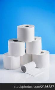 Rolls of toilet paper on a blue background. Panic purchase of essential goods. The coronavirus epidemic in the world.. Rolls of toilet paper on a blue background. Panic purchase of essential goods. The coronavirus epidemic.