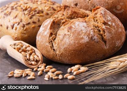 Rolls or bread with seeds on wooden spoon and ears of rye grain. Rolls or bread with seeds and ears of rye grain