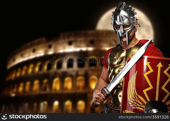 Roman legionary soldier in front of coliseum at night time