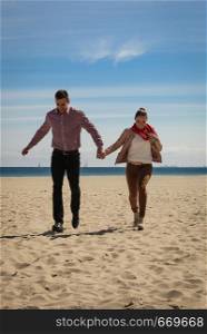 Romance, beautiful relantionship concept. Happy couple having date on beach near sea running on sand.. Happy couple having date on beach