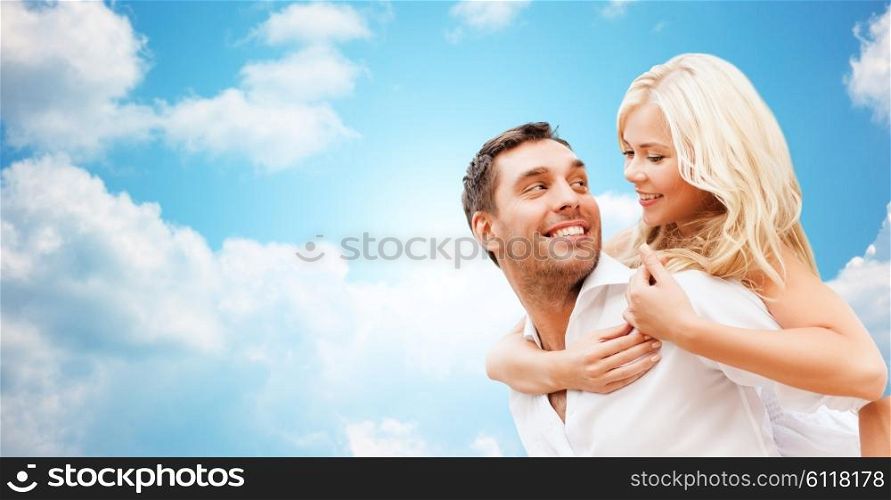 romance, people, love and dating concept - happy couple over blue sky and clouds background