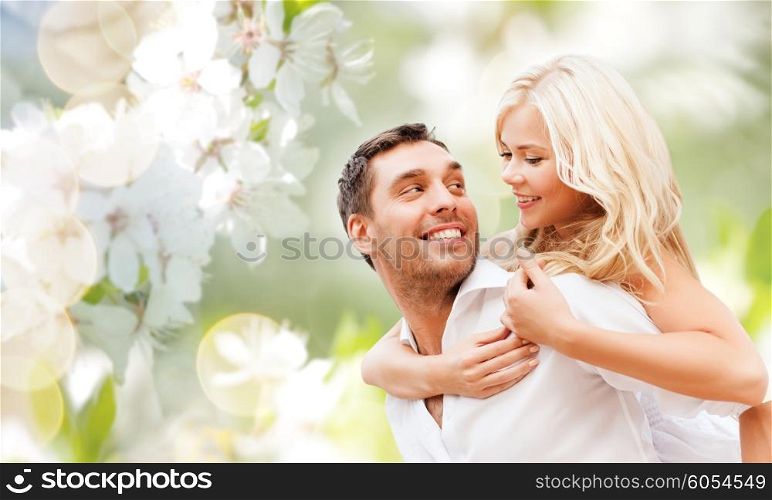 romance, people, love and dating concept - happy couple over cherry blossoms background