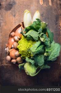 Romanesco with fresh vegetables in dish on rustic wooden background, top view