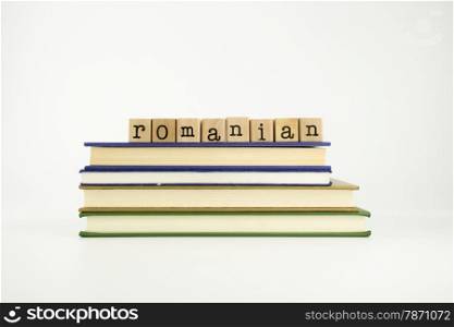 romanian word on wood stamps stack on books, language and conversation concept