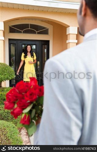 Romantic African American Man Bringing Flowers to Wife or Girlfriend