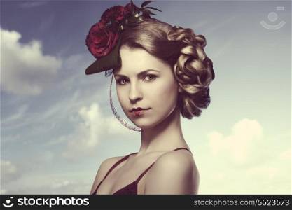 romantic blonde girl with creative elegant hair-style with red roses on her head, red dress and heart shaped lipstick