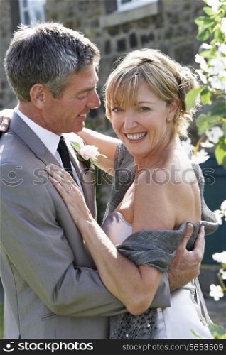 Romantic Bride And Groom Embracing Outdoors