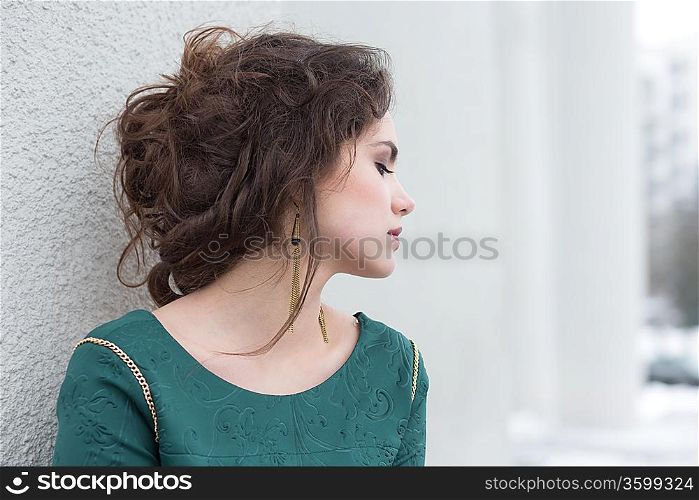Romantic Caucasian Woman in Green Dress over White Wall outside. Solitude