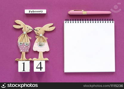 Romantic composition Cubes calendar February 14th Pair of wooden lovers figurine rabbits, open blank notebook for text with pen on purple background Concept Valentine&rsquo;s card Top view Flat Lay Mockup.. Romantic composition Cubes calendar February 14th Pair of wooden lovers figurine rabbits, open blank notebook for text with pen on purple background Concept Valentine&rsquo;s card Top view Flat Lay Mockup