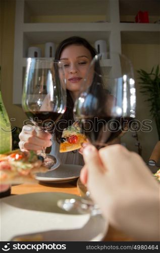 Romantic couple dating at home. Drinking red wine, eating fresh homemade pizza. Photo from the first person