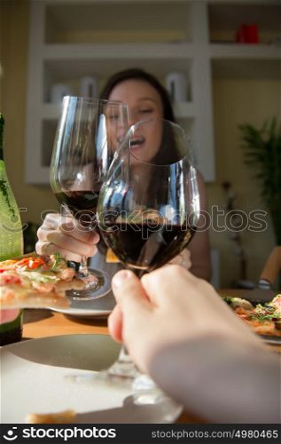 Romantic couple dating at home. Drinking red wine, eating fresh homemade pizza. Photo from the first person