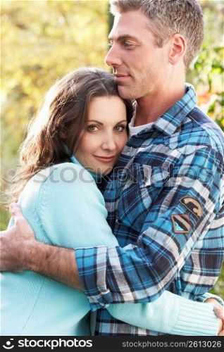 Romantic Couple Embracing By Autumn Woodland