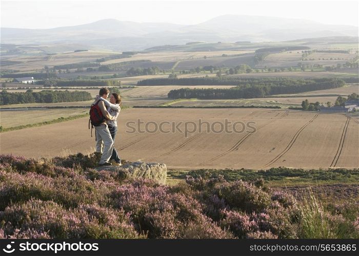 Romantic Couple Hiking Across Moorland Covered With Heather