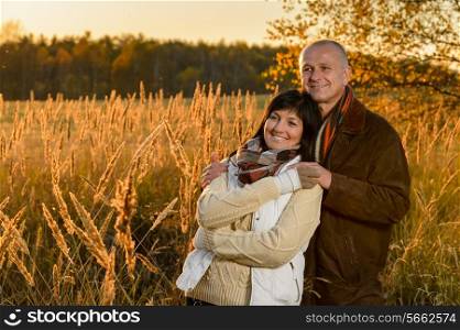 Romantic couple hugging enjoy autumn sunset countryside looking away