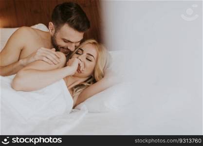 Romantic couple in love lying in bed at home together