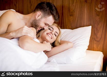 Romantic couple in love lying in bed at home together