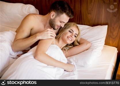 Romantic couple in love lying in bed at home together