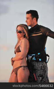 romantic couple in surf wear posing at beach on sunset at summer season