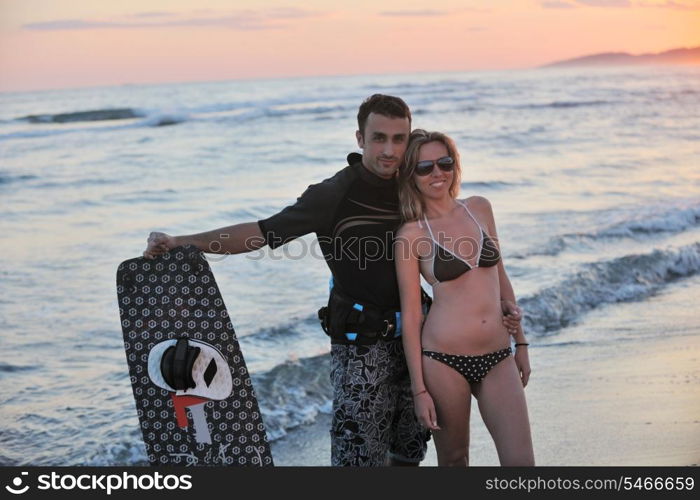 romantic couple in surf wear posing at beach on sunset at summer season