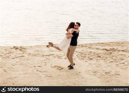 Romantic couple is hugging and having fun outdoors. elegant and stylish woman and man in love are walking along the lake. Happy moments together. love story.. Romantic couple is hugging and having fun outdoors. elegant and stylish woman and man in love are walking along the lake. Happy moments together. love story
