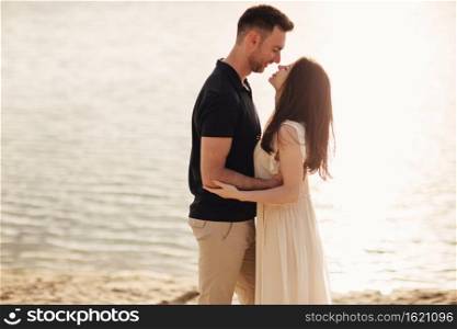 Romantic couple is hugging outdoors. elegant and stylish woman and man in love are walking along the lake. Happy moments together. love story.. Romantic couple is hugging outdoors. elegant and stylish woman and man in love are walking along the lake. Happy moments together. love story