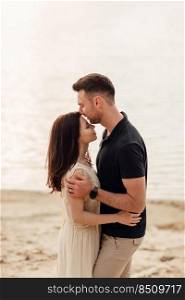 Romantic couple is kissing outdoors. elegant and stylish woman and man in love are walking along the lake. Happy moments together. love story.. Romantic couple is kissing outdoors. elegant and stylish woman and man in love are walking along the lake. Happy moments together. love story