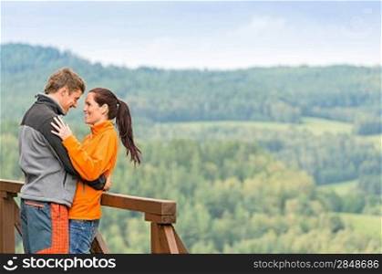 Romantic couple looking at each other on landscape background