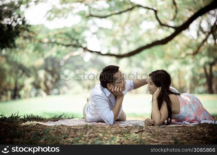 Romantic Couple Lying On Field At Park