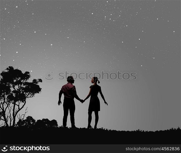 Romantic couple. Silhouettes of young romantic couple standing under the moon light