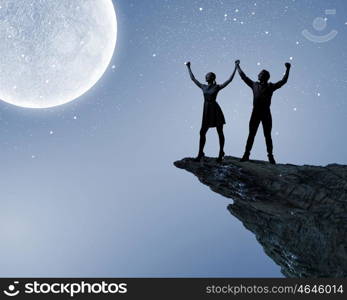 Romantic couple. Silhouettes of young romantic couple standing under the moon light