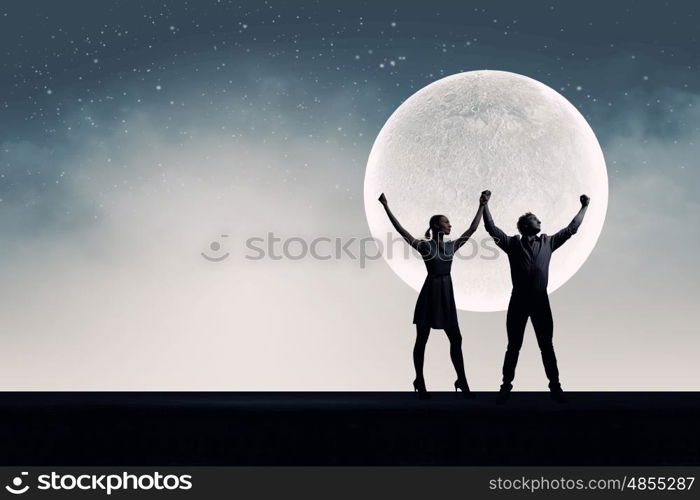 Romantic couple. Silhouettes of young romantic couple standing under the moon light