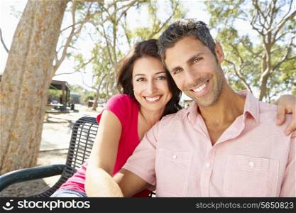 Romantic Couple Sitting On Park Bench Together