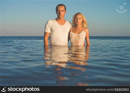 Romantic couple standing waist-deep in the sea