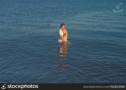 Romantic couple standing waist-deep in the sea
